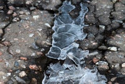 Asphalt cracks full of ice