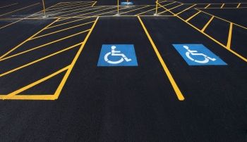 Fresh asphalt parking lot with two painted handicap spots