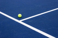A tennis ball on a blue sport court