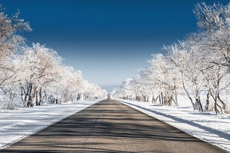 A road with snow on the banks to both sides of it