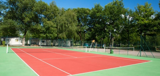 A red tennis court with a green border - How Often Do Tennis Courts Need Resurfacing?