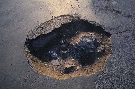 A large pot hole in pavement