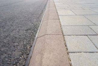 Asphalt with a banked curb and stone tile walkway