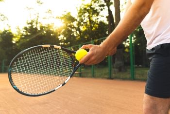 A man holding a tennis racket about to serve the ball